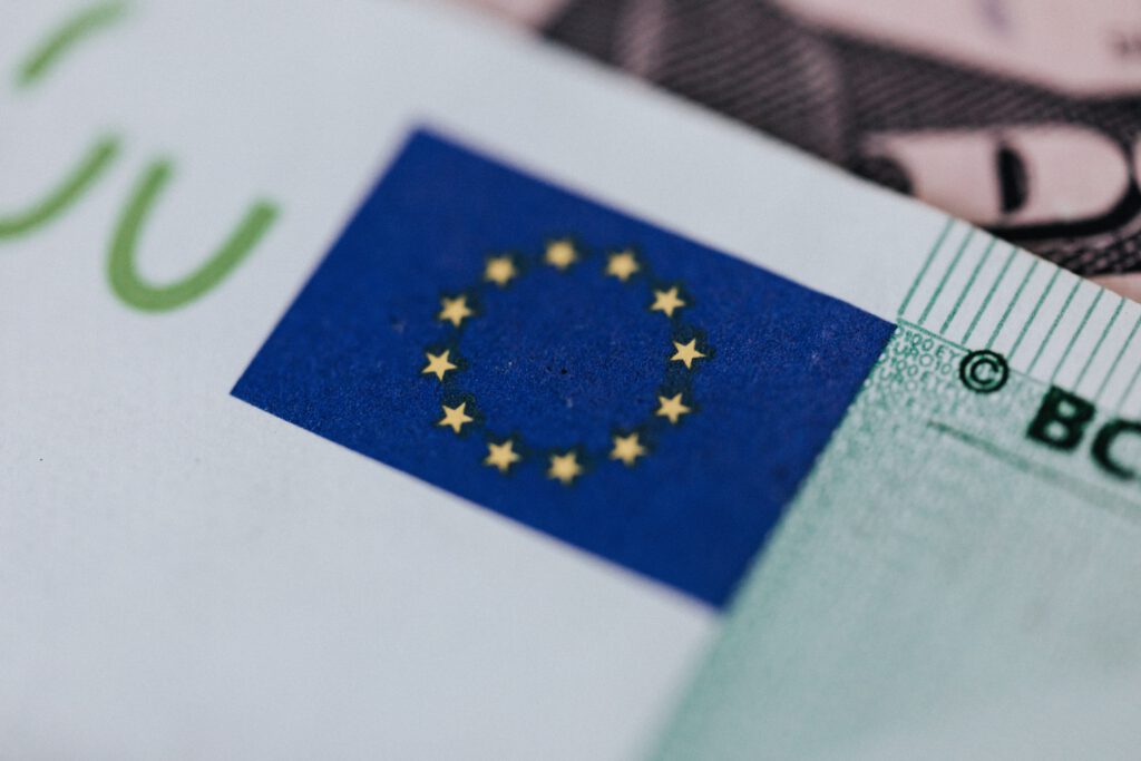 Egy euro bankjegy az európai unió zászlójával.